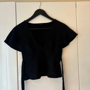 svart topp med knyte i ryggen Gina Tricot - använd fåtal gånger, knyte i ryggen