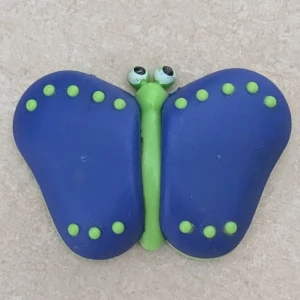Blå och grön fjäril magnet  - Cool magnet i form av en fjäril med blå vingar och gröna prickar samt kropp. Ögonen är vita med svarta pupiller och baksidan är helt grön. En Magnet med en färgglad och lekfull touch.
