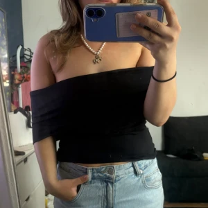 Svart offshoulder tubtopp - Säljer en svart offshoulder topp. Från pull and bear och är så snygg! Storlek L , men passar bra på mig som bär M/ S 