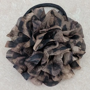 Blomma med elastisk snodd, säkerhetsnål, hårklämma - Snygg stor tygblomma i leopardmönster kan användas som exempelvis brosch. Blomman är gjord av lätt och transparent syntetmaterial i bruna och svarta toner. Fästet har både hårklämma , säkerhetsnål och elastisk snodd, så du kan styla det som du vill. Perfekt för att ge din look extra edge.