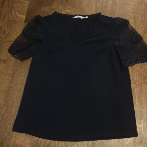 Svart blus med spetsärmar och v-ringning - Jätte söt volang aktig blus! Köpt i Frankrike så går inte att få tag på lätt💕 kom priv för bild på!