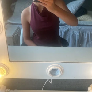 Vinröd halterneck topp med öppen rygg - Säljer en vinröd halterneck topp med snygg drapering vid halsen och öppen rygg. Knappt använd den så är därför i nytt skick . Köpt för 249:-. Storlek S