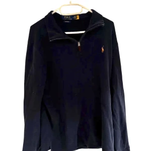 Mörkblå half zip tröja Polo Ralph Lauren - Mörkblå långärmad tröja från Polo Ralph Lauren med klassisk broderad logga på bröstet. Tröjan är i storlek M men skulle kunna vara en tightare L, tröjan är sparsamt använd och i rikigt bra skick. 