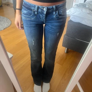 RESERVERADE Blå bootcut jeans från LTB - Säljer ett par snygga blå bootcut jeans från LTB med låg midja och slitna detaljer framtill. Jeansen är i storleken W26/L32 och i modellen valerie. Säljer pga att de är lite stora för mig så jeansen är knappt använda så inga defekter💕💕