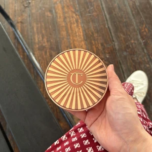 Charlotte Tilbury Beautiful Skin Bronzer - Säljer en Charlotte Tilbury Beautiful Skin Sun-Kissed Glow Bronzer i färgen Fair/Pale. Krämig formula som ger en naturlig solkysst look. Kommer i en snygg rund guldig dosa med spegel och ikoniskt CT-mönster på locket. Perfekt för att skulptera och värma upp ansiktet.