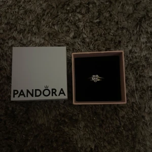 Guldfärgad promise ring från Pandora - Promise ring från pandora i ca 5 cm i omkrets (ungefär EU 50). Välanvänd men fortfarande i fint skick. 