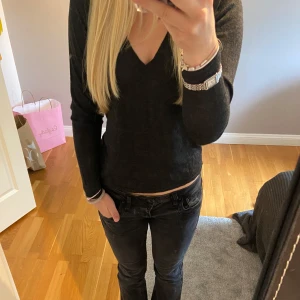 Svart v-ringad tröja - Säljer en svart långärmad tröja med v-ringning. Tröjan har en enkel och stilren design som passar perfekt till jeans eller kjol. Materialet känns mjukt och bekvämt mot huden och passformen är normal. Perfekt för dig som gillar en clean och klassisk look. Använd fåtal gånger. 🩷