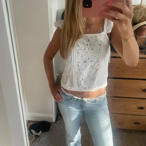 Vit broderad blus med volangärmar - Superfin vit blus med broderade detaljer och små volangärmar.  Passar perfekt på sommaren eller under en kofta! Pris kan diskuteras 