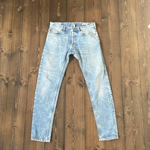 Ljusblå jeans från M. Grifoni - Säljer ett par ljusblå jeans från M. Grifoni med klassisk femficksdesign och raka ben. Jeansen har en snygg tvättad look och orange kontrastsömmar. Perfekta för dig som gillar en avslappnad stil.