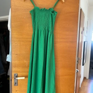 Grön långklänning - En så fin grön klänning som är perfekt till sommaren. Endast använd en gång. 