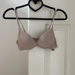 Beige bh från H&M - Beige bh från H&M med justerbara axelband. Har lite push up. Har några fläckar som inte går bort efter tvätt (se bilder). Är använd, går att diskutera pris pga fläckarna. STORLEK 75A