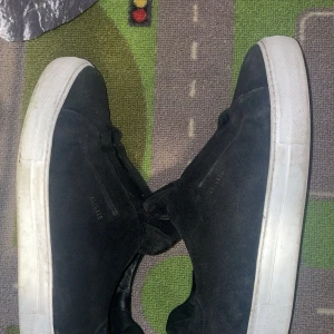 Svarta sneakers från Axel Arigato - Säljer ett par svarta sneakers från Axel Arigato med vit sula. Dem är i gott skick! Dem är i storlek 44! Dem är väldig fina och bra till sommaren om du vill ha en fresh och ren still! Dem finns i Göteborg! Priset går att diskutera! 