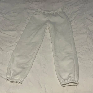 Vita mjukisbyxor från SHEIN - Vita mjukisbyxor från SHEIN med resår i midjan och vid bensluten. Byxorna är enkla och har en avslappnad passform, perfekta för en chill look. Tillverkade i mjukt material som känns skönt mot huden.