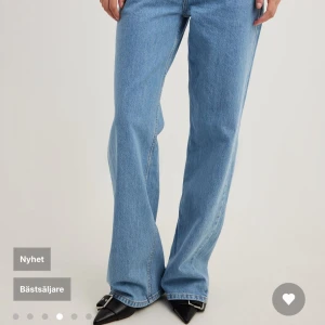 Blå wide leg jeans från NA-KD - Säljer ett par ljusblå jeans med wide leg och låg midja från NA-KD. Jeansen har klassisk femficksdesign, raka ben och stängs med dragkedja och knapp. Perfekta för en avslappnad och trendig look. Glömde skicka tillbaka de därför de säljs helt oavnvända jätte långa i benen så om man är kortare som jag så klipper jag de lite men perfekt för de som är längre! Jag är en 34 i vanliga fall men 32 passar super bra men passar även ni som är 32 
