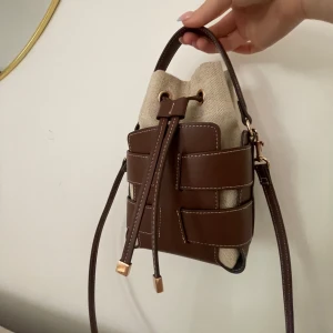 Brun / beige bucket bag med axelrem från H&M  - Säljer min bucket bag i färgen brun/ beige från H&M 