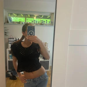 Svart volangtopp med hålmönster från Zara - Säljer en svart croppad topp från Zara med volangärmar. Toppen har rund halsringning och är perfekt för dig som vill ha en trendig look. Aldrig använd pga fel storlek. Pris kan diskutera 
