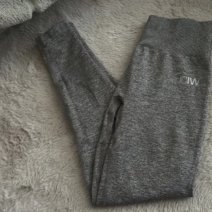 Grå/belgie tights från ICANIWILL - tights från ICANIWILL med hög midja och ribbad linning. Perfekta för träning och har en tight passform. Materialet är stretchigt och mjukt för maximal komfort.