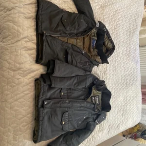 Svart vinterjacka från Svea - Säljer en svart vinterjacka från Svea med grönt quiltat foder. Jackan har huva, dragkedja och knappar framtill samt flera fickor med lock. Klassisk patch på ena ärmen och ribbade muddar vid ärmslut och krage.storlek s. Dom är nästan likadana mycket bra kvalitet och skick Hämtas i norsborg botkyrka eller fraktas.