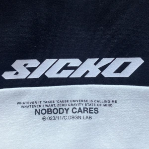 Svartvit hoodie från Cropp med Sicko-tryck - Säljer en svart och vit hoodie från Cropp med stor 'SICKO' text på bröstet och texten 'NOBODY CARES' under. Hoodien har känguruficka och dragsko i huvan. Loose fit-modell, perfekt för en avslappnad stil.
