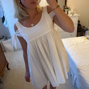 Vit klänning - Otroligt vacker klänning med rosetter i 100% bomull. Använd endast i några timmar, utan anmärkningar! Perfekt nu i sommar eller som studentklänning🤍🤍🤍