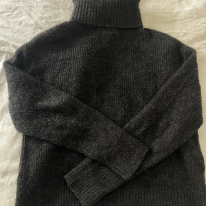 Svart stickad polotröja - Mysig svart stickad tröja med en loose passform. Sparsamt använd!!