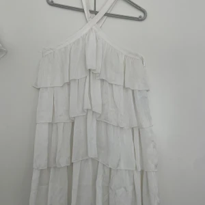 Studentklänning bubbleroom - Superfin vit studentklänning med flera lager volanger och smala axelband som korsas i ryggen. Slutsåld på bubbleroom. Riktigt smickrande men va för stor och returtiden är ute, vill bara inte gå back☀️Lappen kvar helt oanvänd. Om ni bor i sthlm kan jag överlämna direkt såklart. 