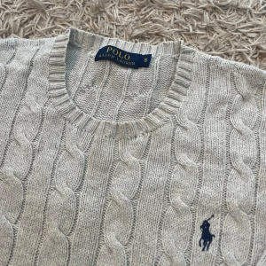 Grå kabelstickad tröja från Polo Ralph Lauren small grisch oldmomey stockholm style laidback  - Snygg ljusgrå kabelstickad tröja från Polo Ralph Lauren. Tröjan har en broderad marinblå logga på bröstet. Perfekt för en avslappnad och stilren look. Storlek S men mått kan såklart skickas vid osäkerhet. Använd men inga märkvärdiga defekter. Postas antigen samma dag som köp eller dagen därpå🙌💯
