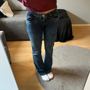 Blå bootcut jeans från LTB - Snygga blå jeans från LTB med klassisk bootcut-passform och låg midja. Jeansen har fem fickor, ljusare tvättade partier och detaljerade bakfickor. Tillverkade i mjukt denim med lite stretch för extra komfort. Helt nya