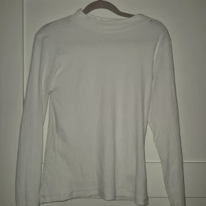 Vit ribbad långärmad tröja H&M - Vit långärmad tröja från H&M i ribbad bomullskvalitet. Enkel och stilren med rund halsringning och smal passform. 