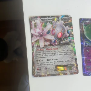 Magearna EX & Gardevoir EX Pokémonkort - Två glittrande Pokémon EX-kort: Magearna EX och Gardevoir EX! Perfekt för dig som vill boosta din samling eller spela med vänner. Korten har coola effekter och färgstarka illustrationer som gör dem till ett måste för alla Pokémonfans.