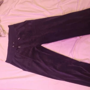 Svarta mjukisbyxor Juicy Couture S - Marinblå mjukisbyxor från Juicy Couture i storlek S. Byxorna har bred resår i midjan med snörning och är gjorda i mjuk sammet. Klassisk relaxed passform med fickor både fram och bak. Perfekta för en chill och trendig look.