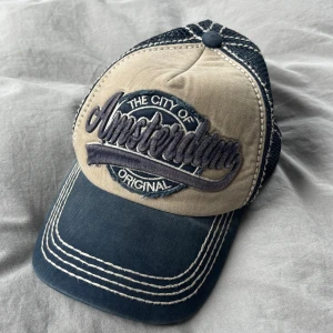 Amsterdam keps blå/beige - Snygg keps. Står ”city of Amsterdam”. Knappt använd! Öppen för prisförslag. Skriv om ni har frågor, vill ha fler bilder osv!💖💖