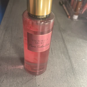 Victoria's Secret Pure Seduction Body Mist - En fräsch och söt body mist från Victoria's Secret i doften Pure Seduction. Flaskan är genomskinlig med rosa vätska och har ett guldigt lock. Doftnoter av juiced plum, crushed freesia och lotus. Rymmer 250 ml. Använd fåtals gånger då det inte riktigt passar min lukt på parfymer💕