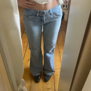 lågmidjade bootcut jeans - Säljer ett par ljusblå bootcut jeans med låg midja. Jeansen har slitna detaljer, hål på baksidan men som inte syns (se bild 2)💕