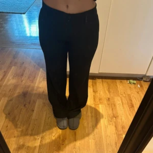 Svarta kostymbyxor - Snygga svarta kostymbyxor med mellan hög midja och rak passform. Byxorna har två knappar i midjan.