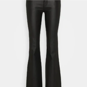 Svarta bootcut skinnbyxor  - Snygga svarta bootcut byxor i syntetmaterial med låg midja och utsvängda ben. Passar bra till både vardag och fest. Bra skick! Storlek 158 men passar bra på mig som är 160 och beukar ha storlek xs 