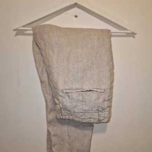 Beige linnebyxor - Snygga beige linnebyxor med knapp och dragkedja. Perfekta för en avslappnad stil till sommaren. 
