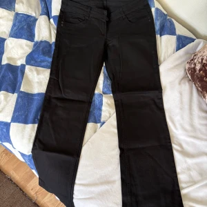 Svarta vintage jeans med coola fickor - Skitcoola svarta jeans från okänt märke. Köpta vintage utomlands. Låg midja och utsvängda. Används knappt längre tyvärr. Midja 42 cm och IBL 78 cm