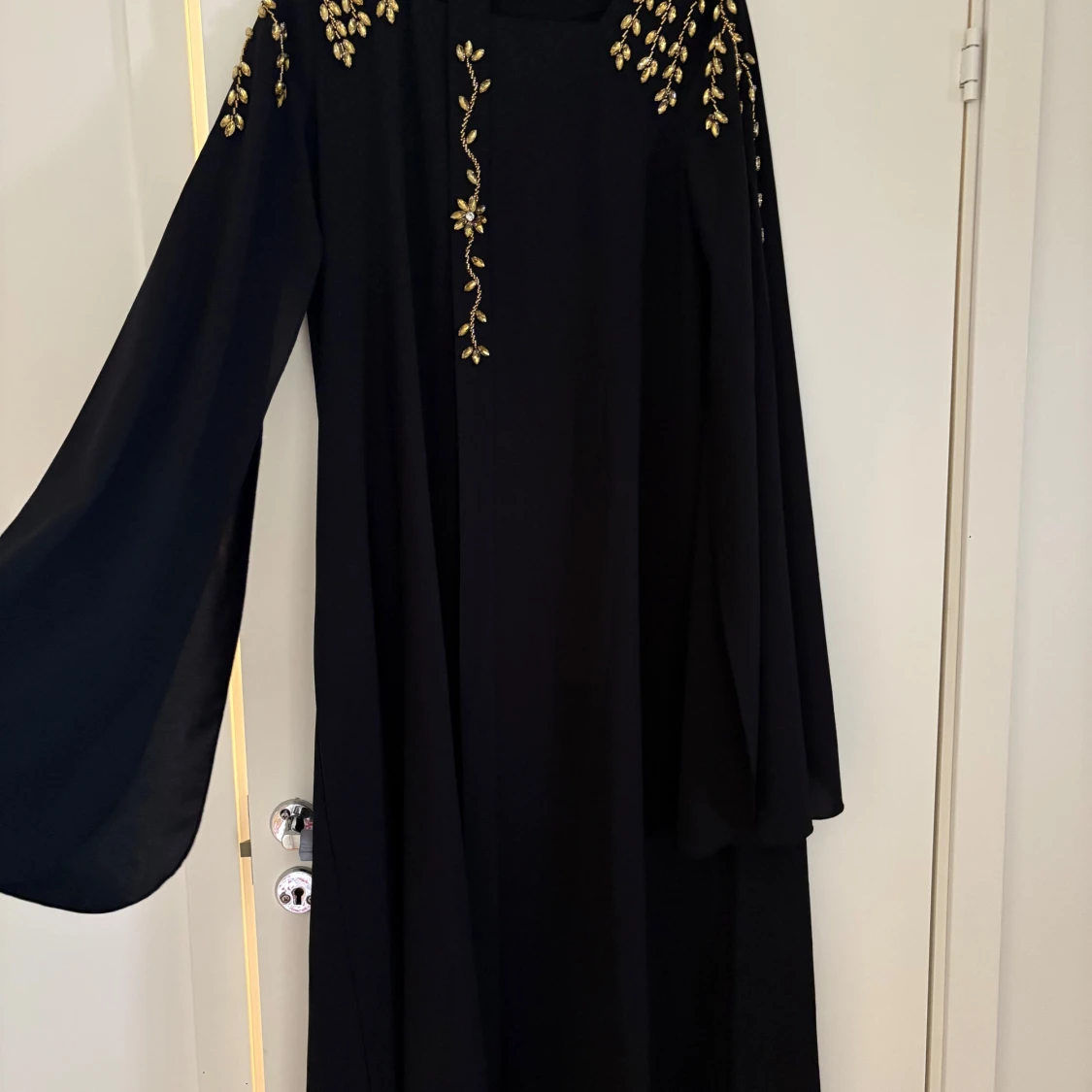 Svart långklänning med guldbroderi