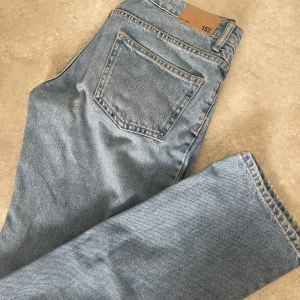 ”icon” jeans från lager 157 - säljer ett par straight leg ”icon” blå jeans från 157 i storlek XS. de har en snygg knappgylf och är i mycket bra skick. sköna och stilrena, knappt använda!!