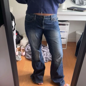 Coola jeans - Mörkblå lågmidjade bootcut jeans med coola slitningar