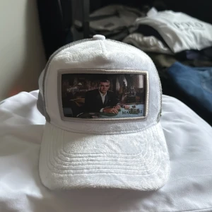 Vit keps med tryck från Maggiore - Snygg vit keps med ett tryck av den gamla James Bond. Kepsen har en justerbar rem baktill och ett nätmaterial för ventilation. Perfekt för en avslappnad stil. Nypris ligger på 899kr men eftersom den inte säljs längre håller jag mig runt den prislappen. Hör gärna av dig vid frågor!