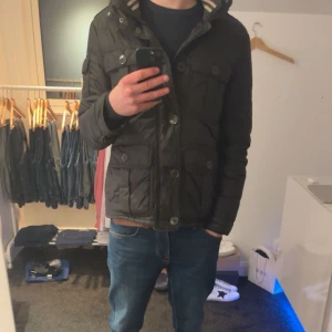 Svart dunjacka från Moncler - Nu har du chansen att förvärva denna perfekta kombinationen av stil och funktionalitet med denna svarta fieldjackan. Denna jacka är designad för den moderna mannen som inte vill kompromissa med varken utseende eller praktiska behov. Med sex rymliga fickor är denna jacka perfekt för att förvara alla nödvändigheter, inklusive kondomer, så att du alltid är redo för en romantisk kväll.den sitter som bäst på dig som är runt 180 cm hög Jackan har infällbara luva i kragen. Hör av dig vid minsta fråga 🔥