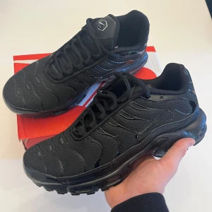 Svarta Nike Air sneakers tns - Snygga svarta Nike Air sneakers med en stilren design och bekväm passform. Skorna har en robust sula och klassisk snörning, perfekt för både vardag och träning.