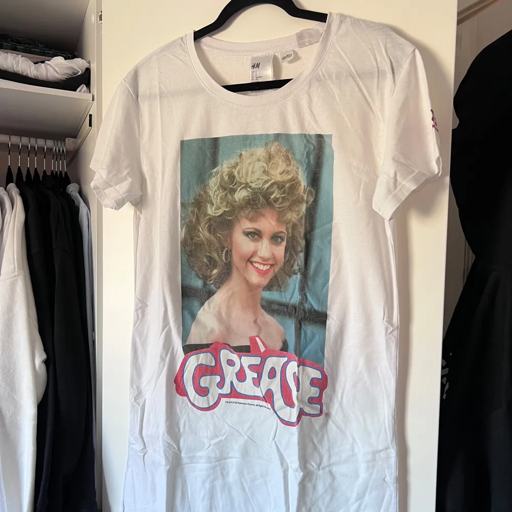 Säljer ett vitt nattlinne från H&M med ett stort tryck av karaktären Sandy från filmen Grease på framsidan. Nattlinnet har korta ärmar och en rund halsringning. Perfekt för filmälskare och retrostil! 🎬 Önskar du veta exakta mått? Tveka inte att höra av dig!. T-paidat.