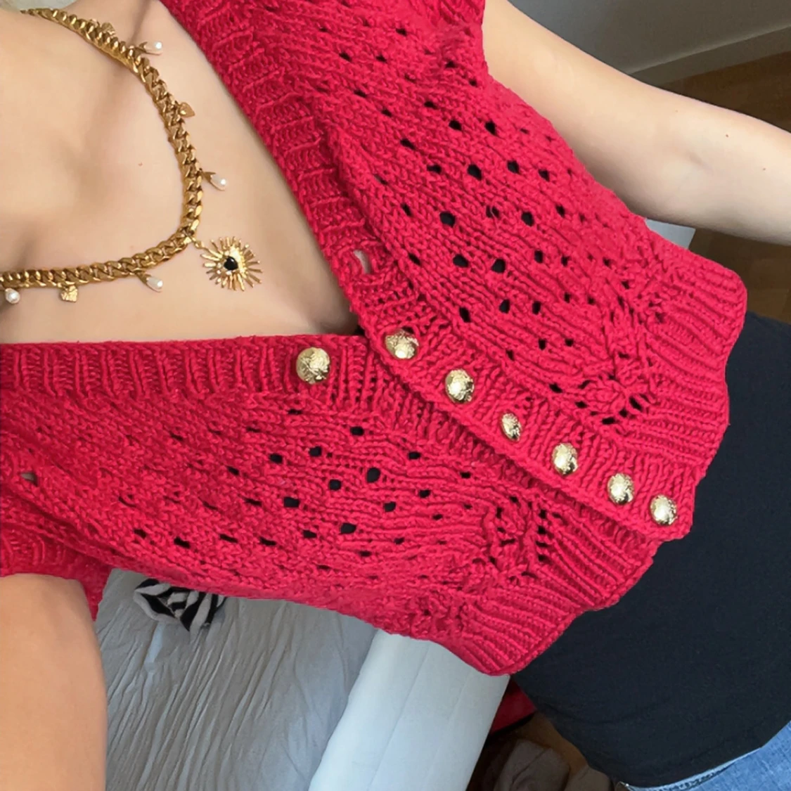 Röd stickad bolero med gulddetaljer
