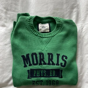 Grön tröja från Morris - Säljer en grön tröja från Morris med text i mörkblått framtill. Stickad och stilig med detaljerna på bröstet. 
