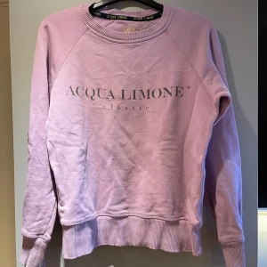 Ljuslila sweatshirt från Acqua Limone - Säljer en ljuslila sweatshirt från Acqua Limone med tryck fram och bak. Tröjan har långa ärmar och ribbade muddar. Perfekt för en avslappnad stil. 💜        Tyvärr har tröjan ett litet hål vid vänster armen men inget som syns!