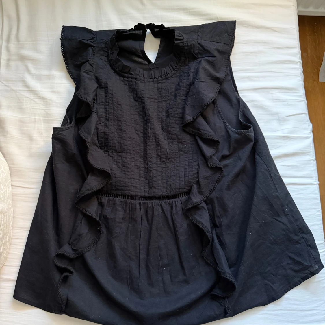 Svart blus med volangdetaljer