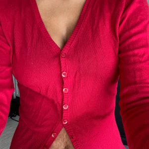 Röd kofta från Vila med v-ringning - Säljer en röd kofta från Vila i storlek M. Koftan har v-ringning, långa ärmar och knappar framtill. Den är stickad i ett mjukt material och har en klassisk, enkel design som är lätt att matcha. Jag har använt ca 2 gånger. Det finns inga tydliga skavanker❤️